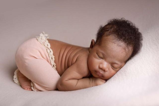 Sleeping newborn baby girl in pink